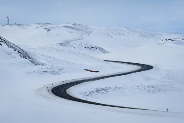 Route dans la neige avec un ciel bleu clair