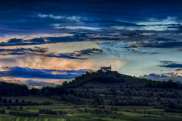 Evening church on a hill against the sunset sky