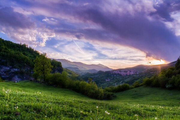 Sonnenuntergang am grünen Berghang