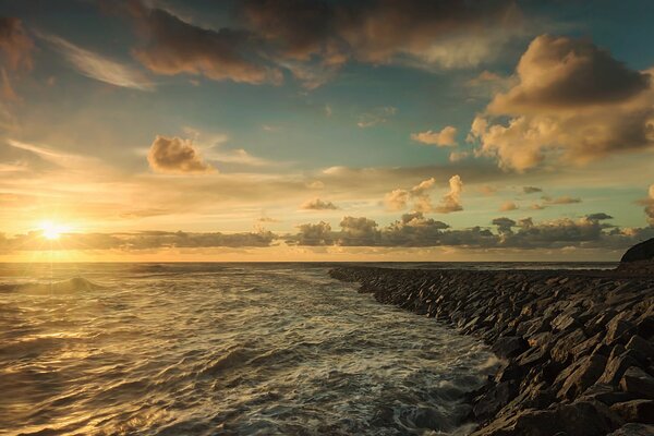 Piana morska skalisty brzeg chmury słońce w zachodzie słońca