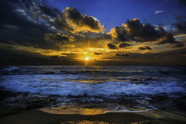 Słońce przedziera się przez chmury nad oceanem