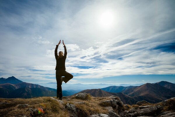 Fille faisant du yoga dans les montagnes