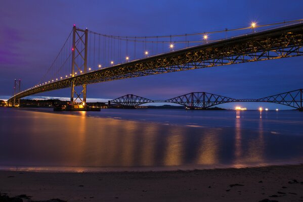 Puente iluminado sobre el río nocturno