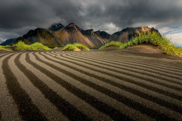 Landscape of mountains, fields and gloomy sky