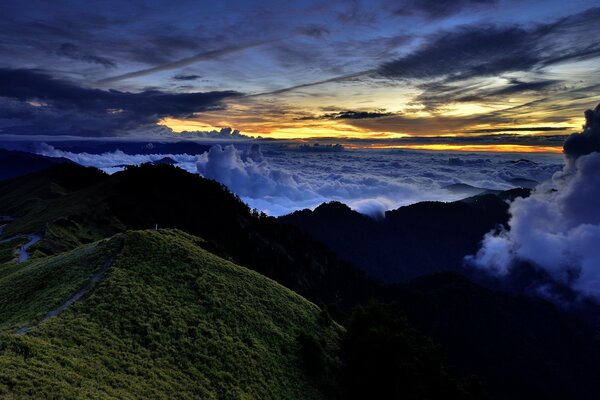 Paesaggio con cielo al tramonto tra le nuvole sullo sfondo delle montagne