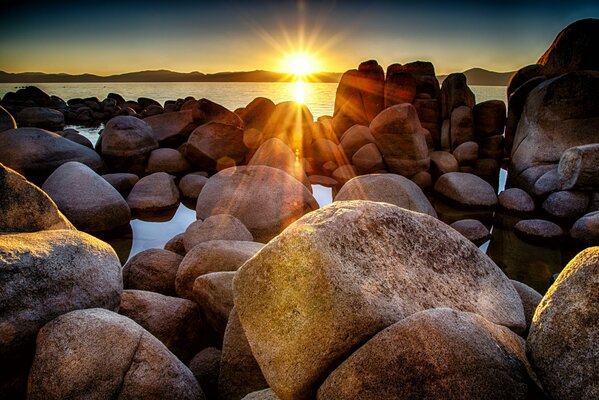 Le soleil couchant jette un coup d œil derrière les rochers de la baie