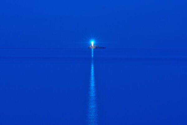 Blaues Meer in der Nacht. Leuchtturm auf der Insel