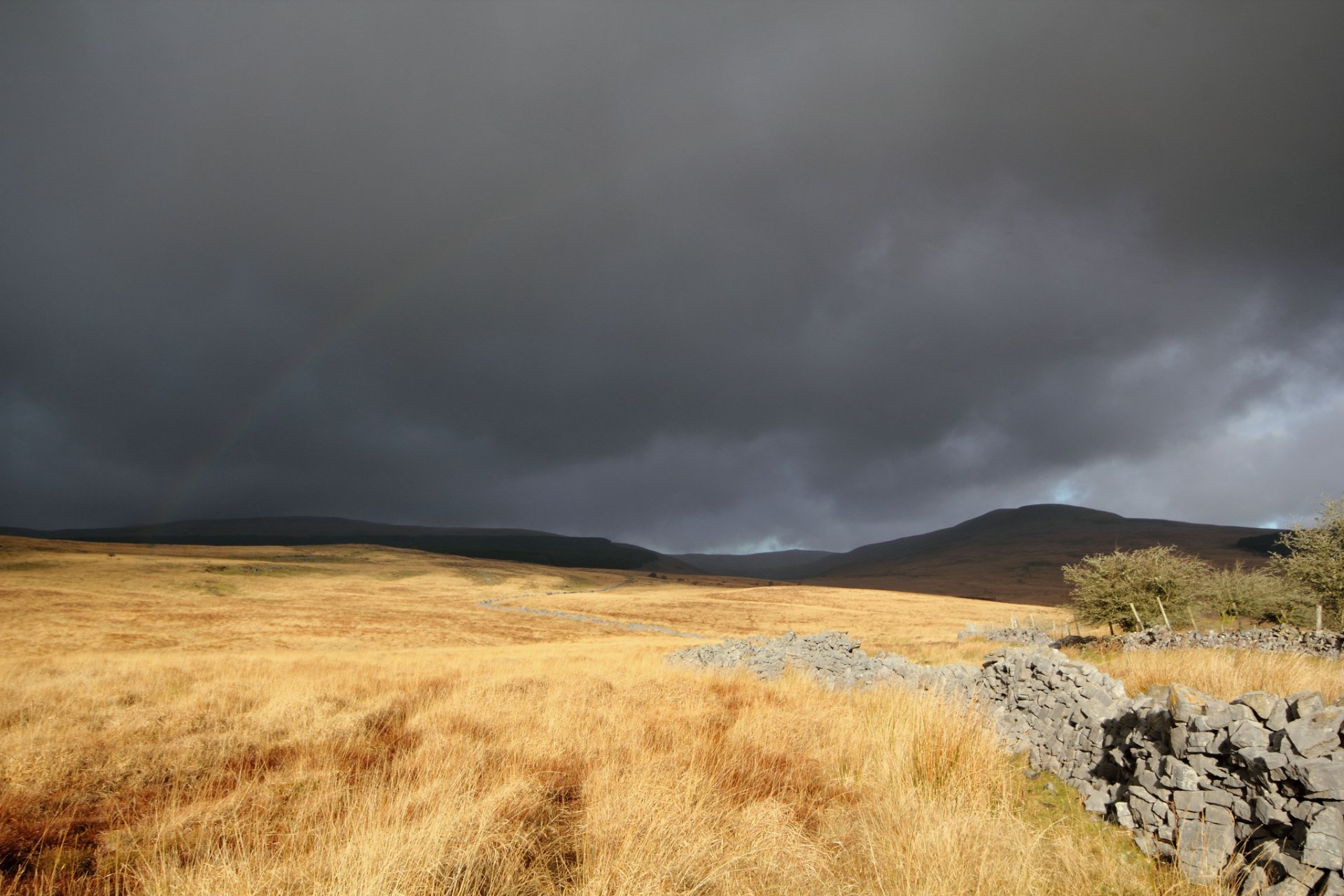 clouds the field masonry stones grass dry rainbow