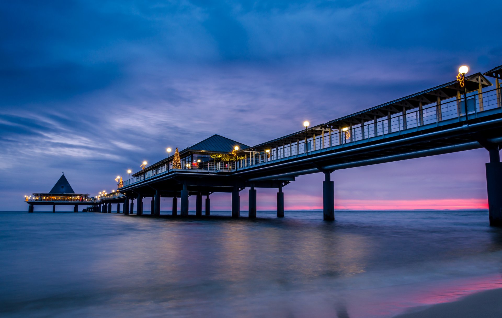 mar costa muelle puente noche azul lila cielo nubes carmesí puesta de sol iluminación luces luz linternas árbol de navidad vacaciones