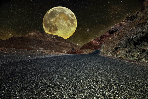 A huge moon in the night between the mountains