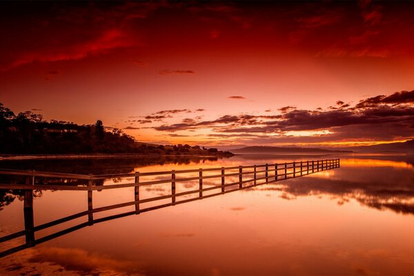 Krwistoczerwony Zachód słońca nad jeziorem. krajobraz