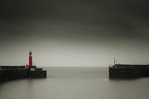 Red lighthouse on the shore of a calm sea