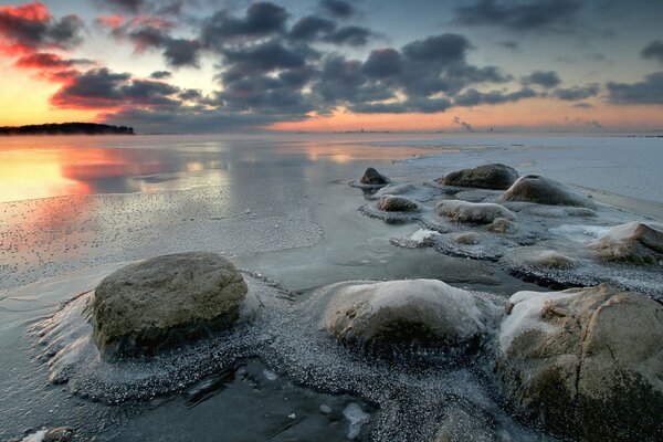 Обледенелые большие камни в морозное утро на побережье