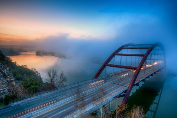 Paesaggio nebbioso. Ponte sul fiume