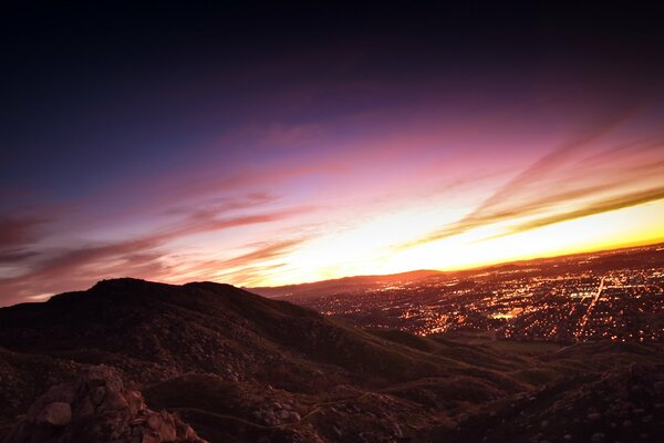 Puesta de sol desde la montaña con vistas a la ciudad