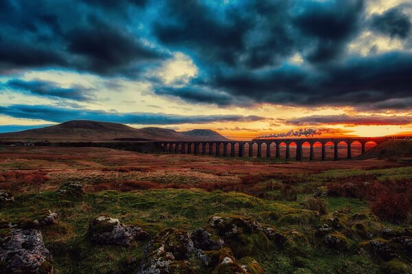 Dark sky over the railway bridge at sunset