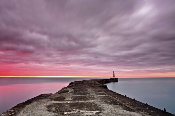 Morgendämmerung am Meer. Pier und Leuchtturm