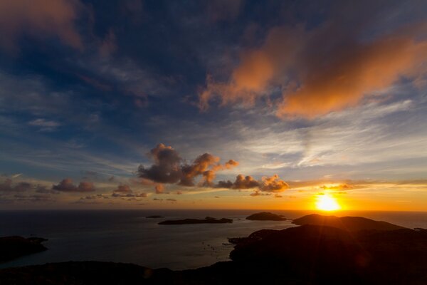 Sonnenuntergang durch die Wolken am Meer