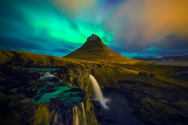 Aurora boreal sobre una montaña alta