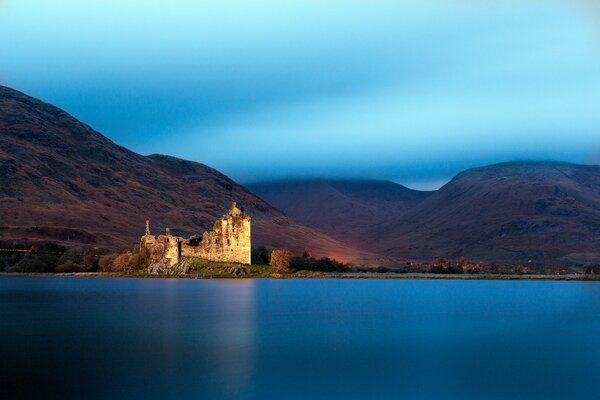 Un lago en Escocia con un castillo en el fondo