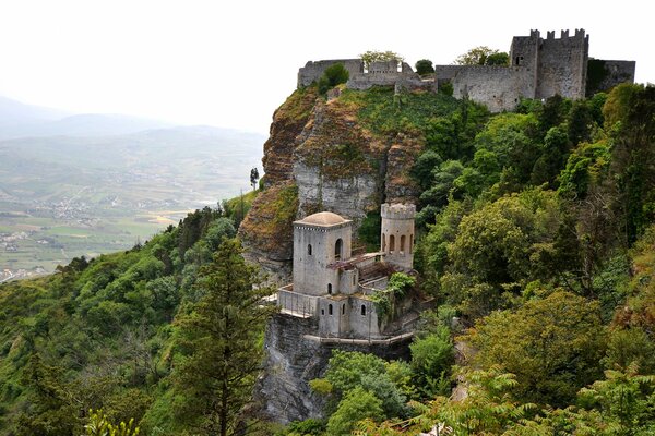 Ein Schloss inmitten von Felsen und Bäumen in Italien