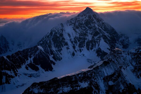 Alba sulla cima di una montagna con nuvole bianche come la neve