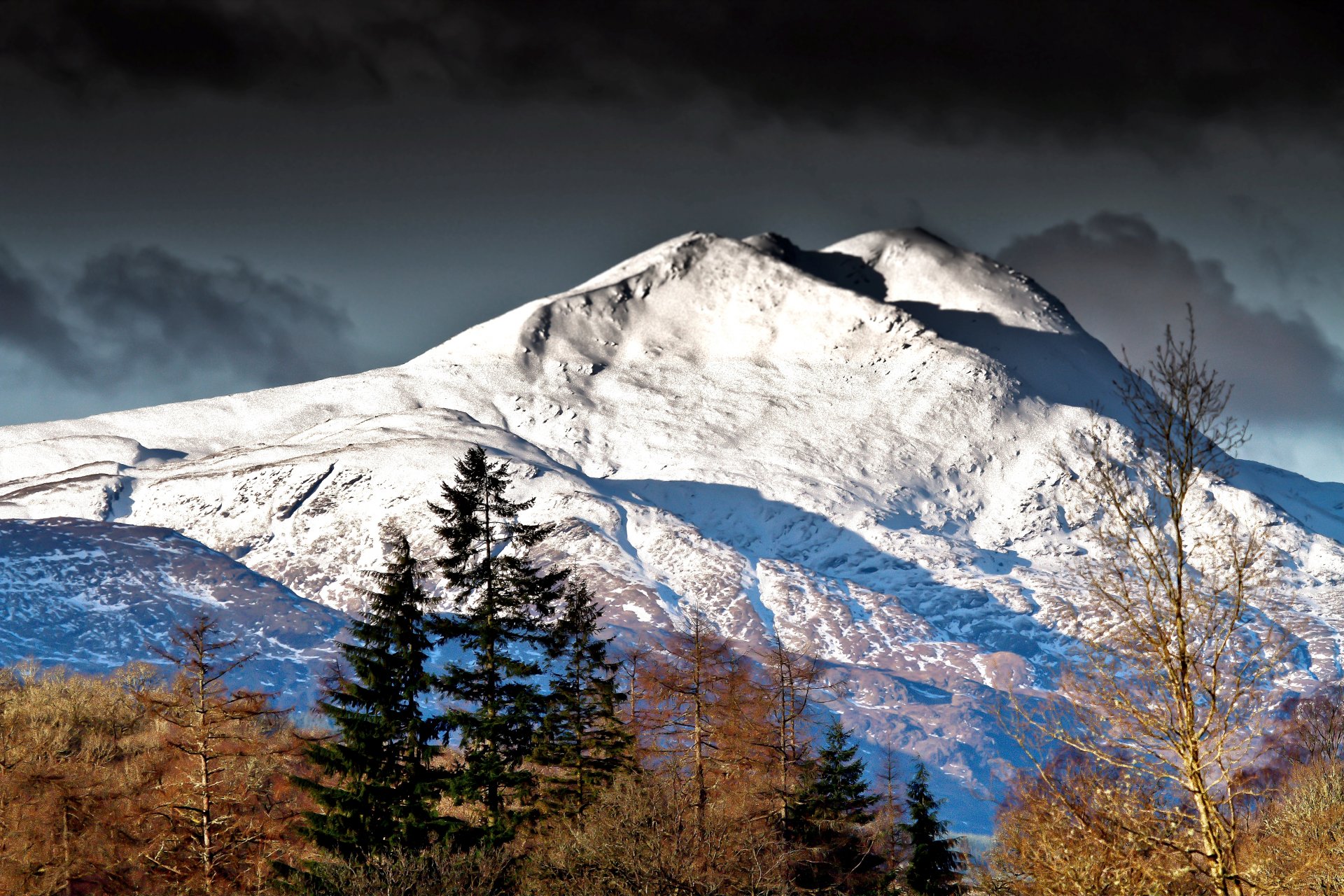 montañas picos pendientes nieve árboles cielo nubes