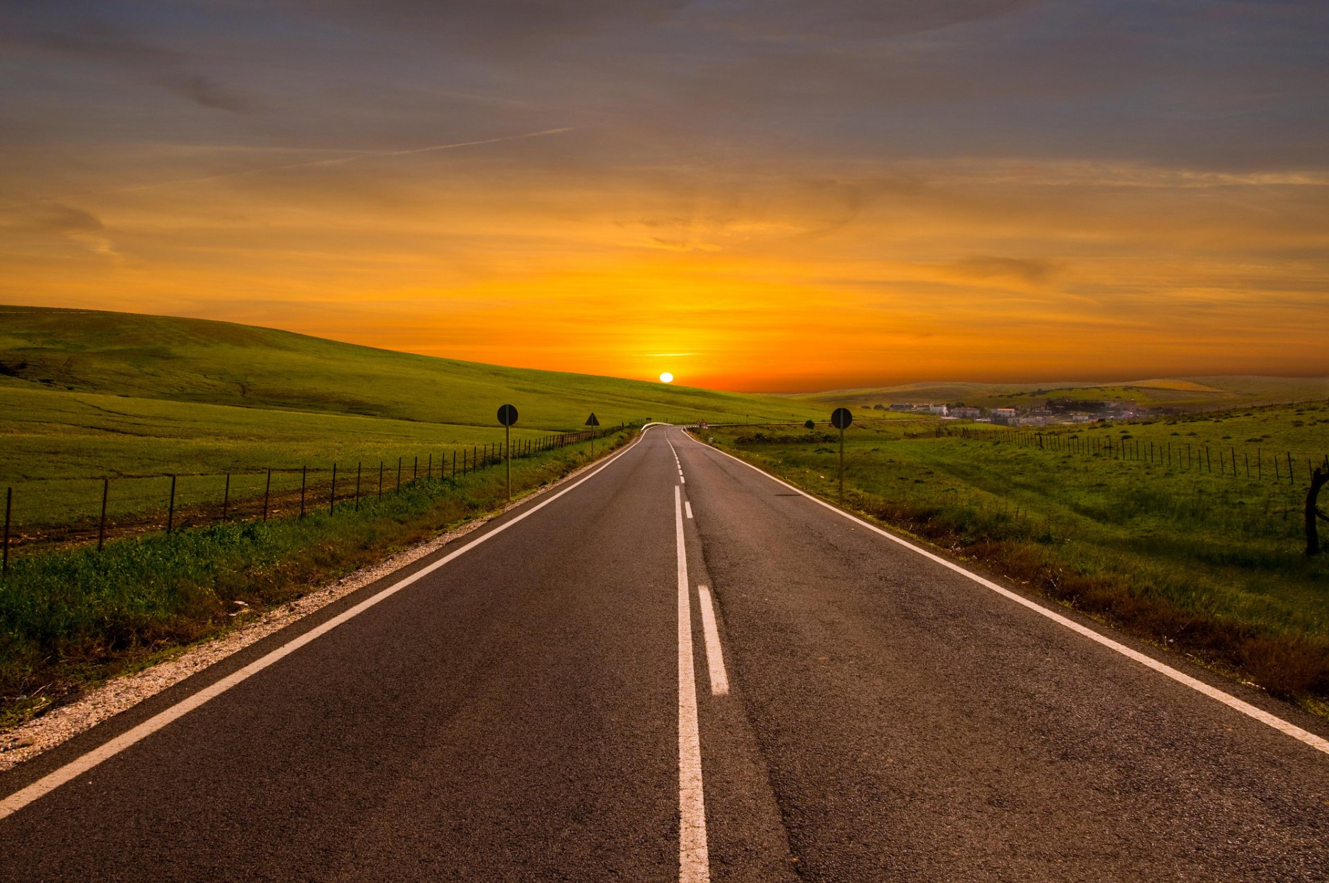 straße in die ferne drehen biegen gelände ansicht landschaft felder gras straßenrand hecke sonne horizont hügel himmel morgenröte