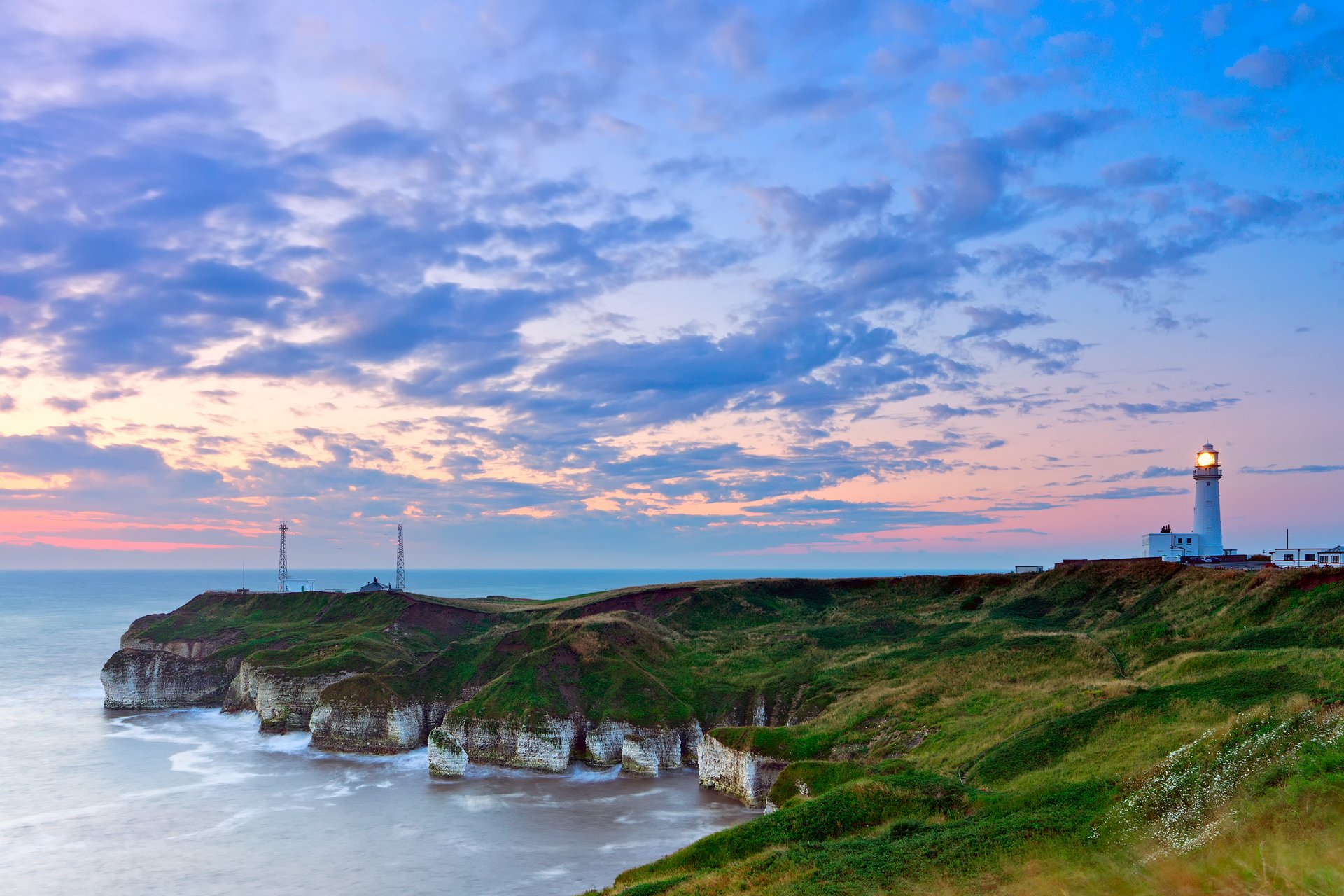 lighthouse on the edge sea beach sky clouds morning