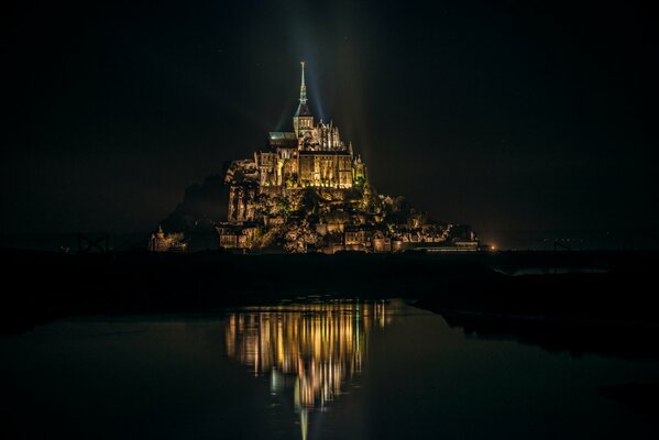 Hermosa iluminación de la fortaleza en la isla de Mont Saint-Michel en Francia