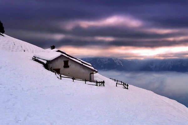 Cabane solitaire dans une congère sur le flanc d une montagne