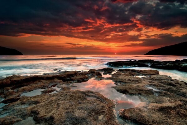 Puesta de sol en el mar. Bahía en la costa