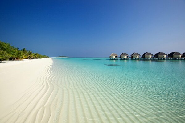 Spiaggia di sabbia bianca mare blu e bungalow