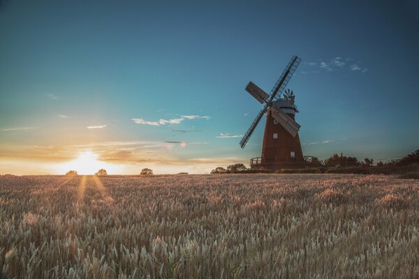 A mill in a field with a beautiful sunset