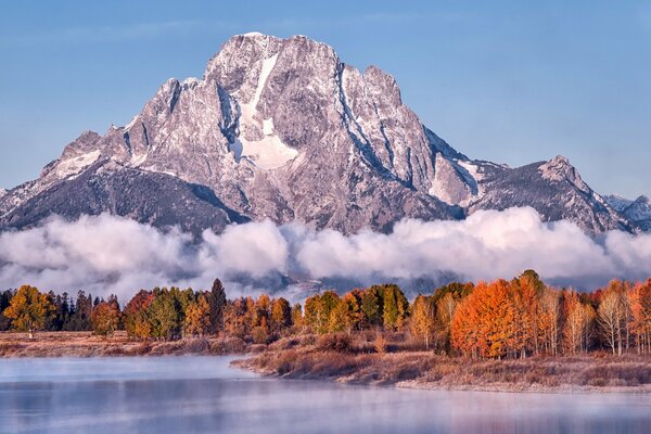 Lago en el fondo de las montañas y el bosque de otoño