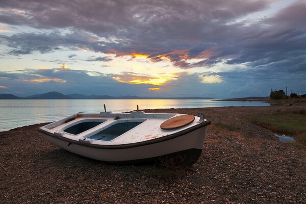 Barca sulla riva al tramonto