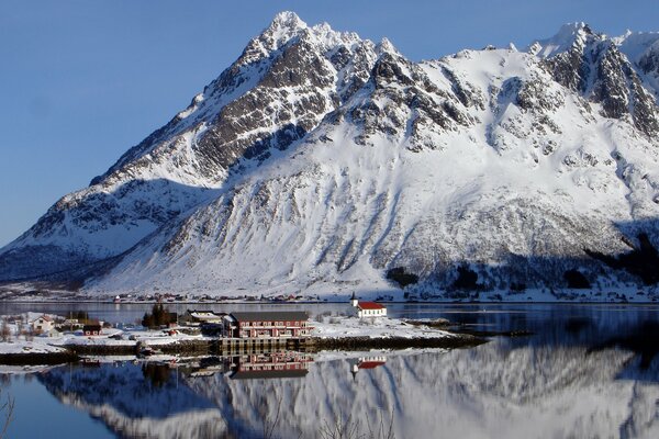 Snow-capped mountains are reflected in the bay