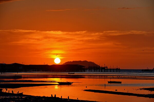 Roter Sonnenuntergang am Meer. Boote in der Bucht