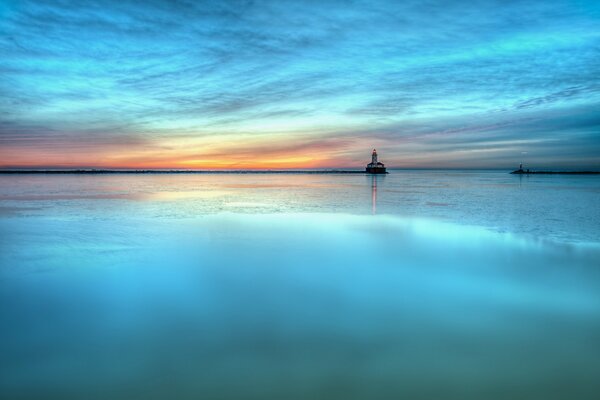 Paesaggio a specchio in tonalità azzurre. Mare al tramonto