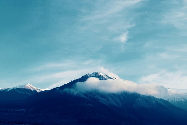 Snow-capped mountain peaks in the clouds