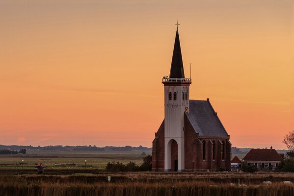 Iglesia del pueblo en el fondo de la puesta de sol