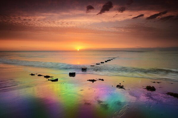 Amanecer arcoiris en la orilla del mar