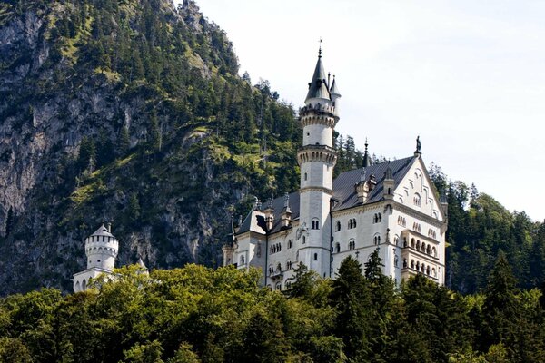 Bavarian castle in the mountains with a white tower