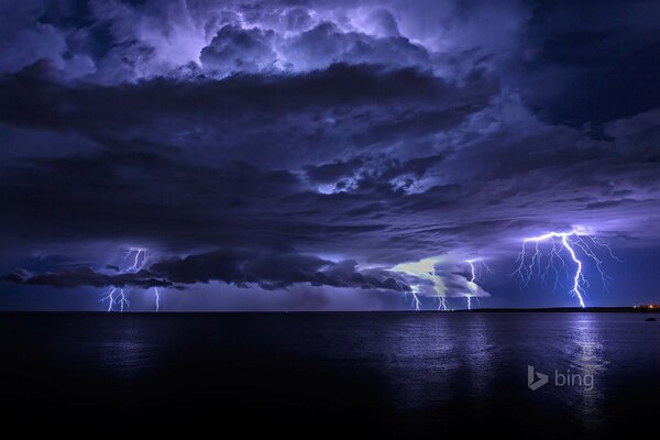 Nubes de tormenta con rayos en el cielo nocturno sobre el mar