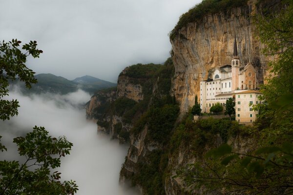 Castillo en la montaña. Una espesa niebla se extiende por debajo de la montaña