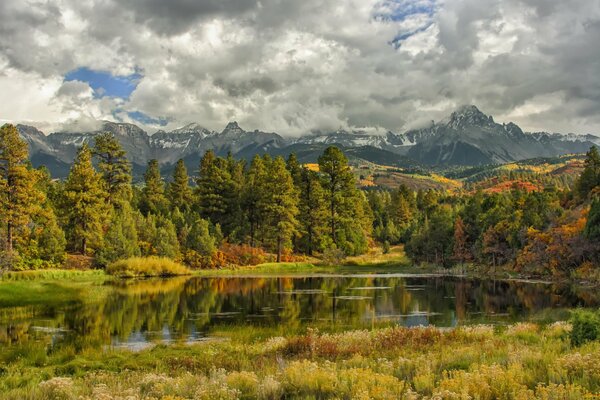 Lake near forest and mountains in autumn