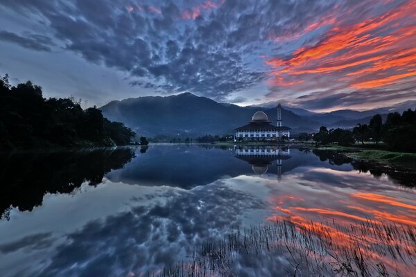 Reflection of the sky and forest in the water at sunset