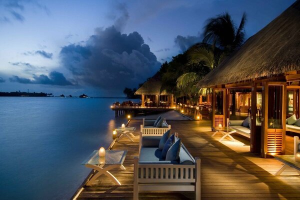 Tropical bungalows on the slope of the evening ocean