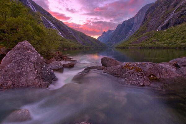 An extraordinary lake in Norway. Mountains covering the sunset