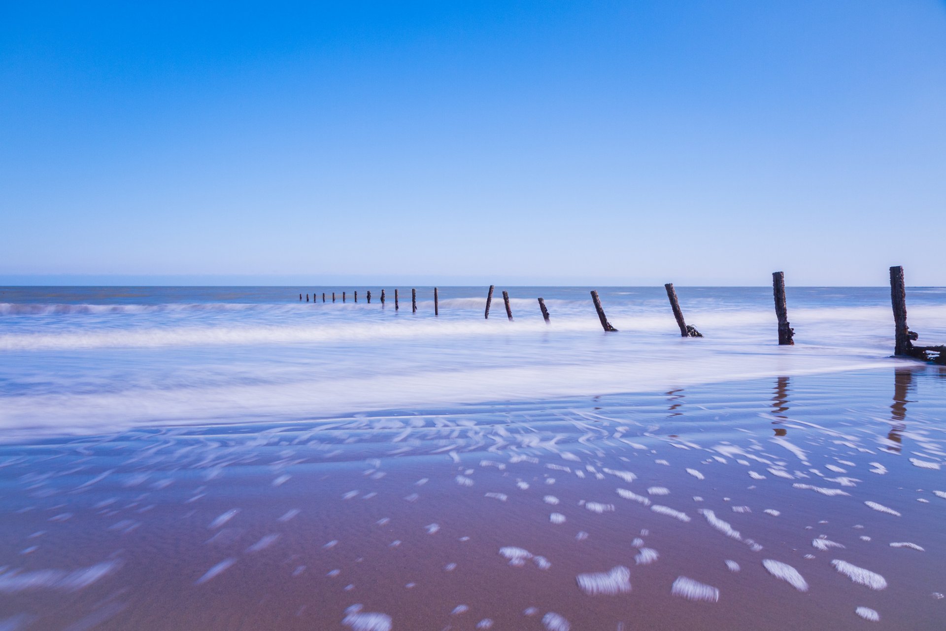 united kingdom england sea foam of the support beach sand blue sky